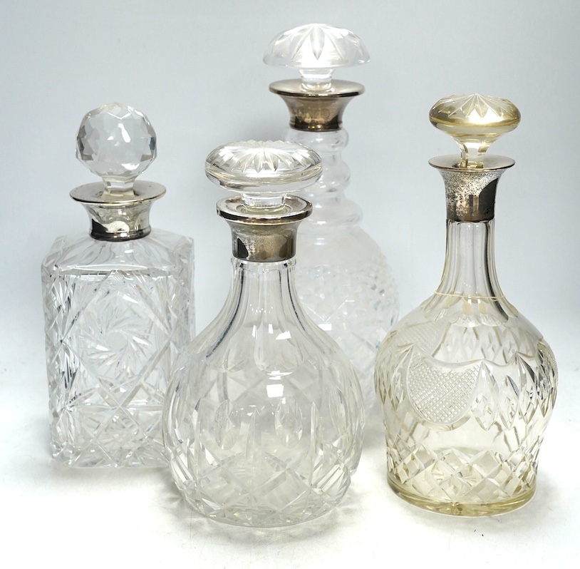 Four silver mounted glass decanters and stoppers, largest 29cm high. Condition - fair to good, one diseased